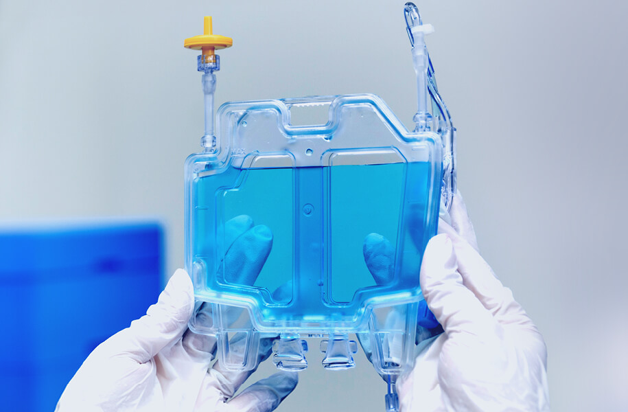 white gloved hands holding a container of clear blue fluid white gloved hands holding a container of clear blue fluid